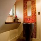 Вузьке панно-мозаїка виділяє зону умивальника у ванній